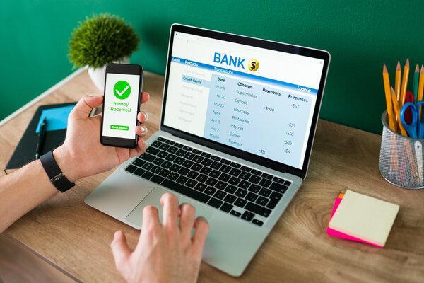 Transferencia de dinero EFT segura en una computadora portátil y un teléfono