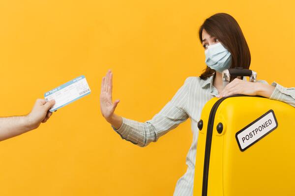 Hand passing plane ticket and passport securely