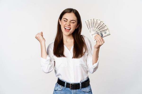 Happy woman holding cash after successful money transfer