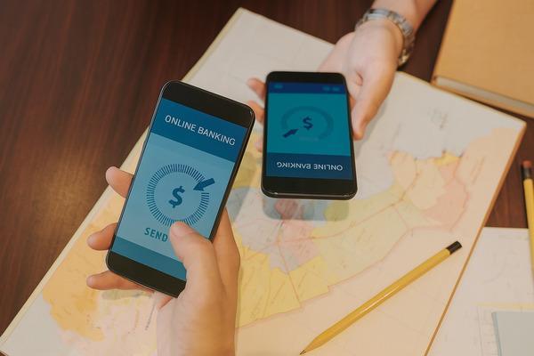 Dos personas que usan teléfonos inteligentes para transferir dinero de forma rápida y segura