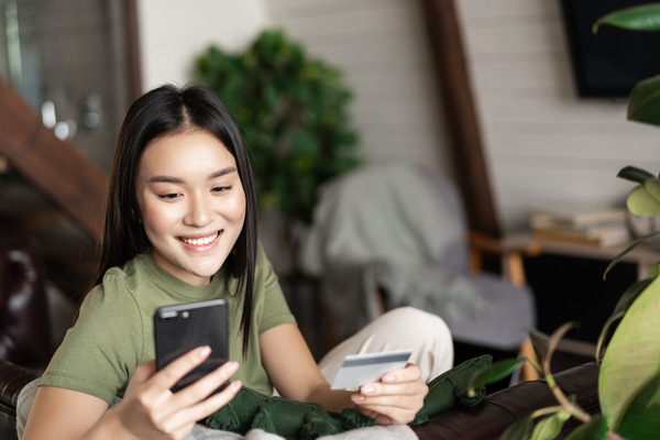 Smiling woman using her phone for a fast money transfer