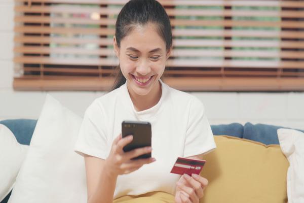 Mujer que usa un teléfono para una transferencia internacional de dinero