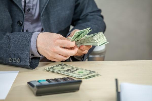 Hombre contando efectivo después de problema de transferencia de dinero