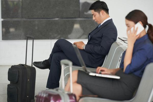 Viajeros de negocios esperando con espacio adicional para equipaje
