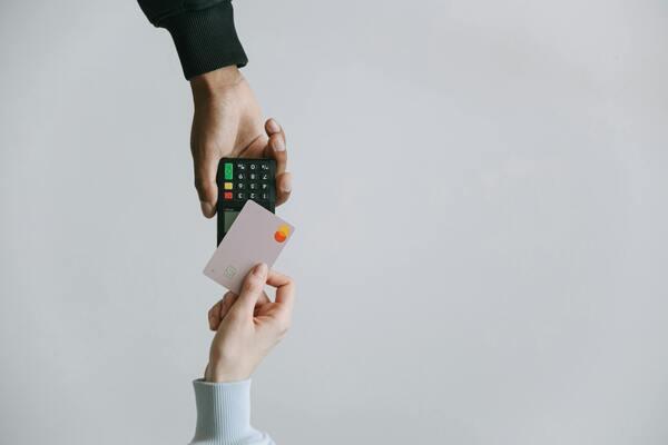 Person making a card payment to manage money transfer rates effectively