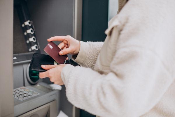 Mujer usando un cajero automático seguro de Bitcoin con tarjeta