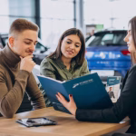 una mujer habla sobre servicios de matriculación de automóviles con una pareja