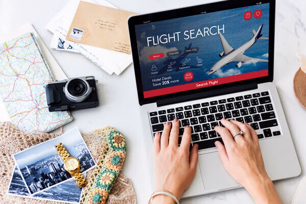 una persona con una computadora portátil buscando el mejor boleto de avión para reservar