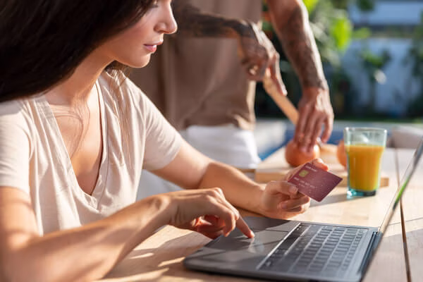 persona que sostiene una tarjeta bancaria y verifica los detalles
