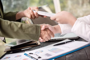 Two people shaking hands during check cashing transaction