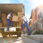 Trabajadores de servicios de mensajería descargando cajas de un camión