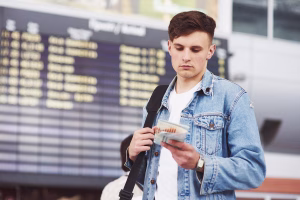 Traveler checking plane tickets at airport terminal