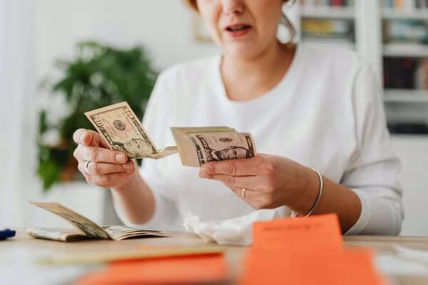 Woman counting money for local check cashing tips