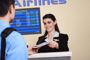 Personal de la aerolínea entregando billetes de avión en el mostrador