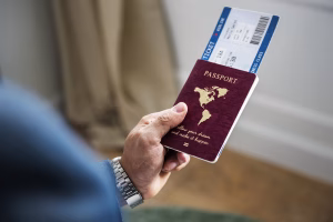Mano sosteniendo el pasaporte y boleto de avión abierto para un viaje flexible