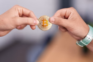 Manos intercambiando Bitcoin por transacción de cajero automático de Bitcoin