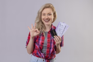 Viajero sonriente sosteniendo una tarjeta y billetes de avión