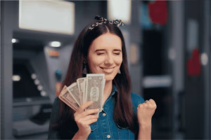 Mujer con efectivo tras retirar Bitcoin de un cajero automático