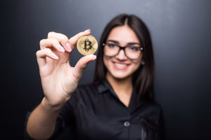 Mujer sonriendo mientras sostiene un bitcoin