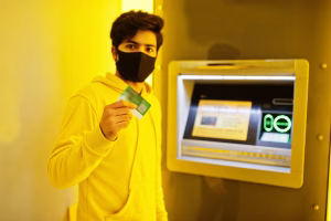 A man holding card near Bitcoin ATM