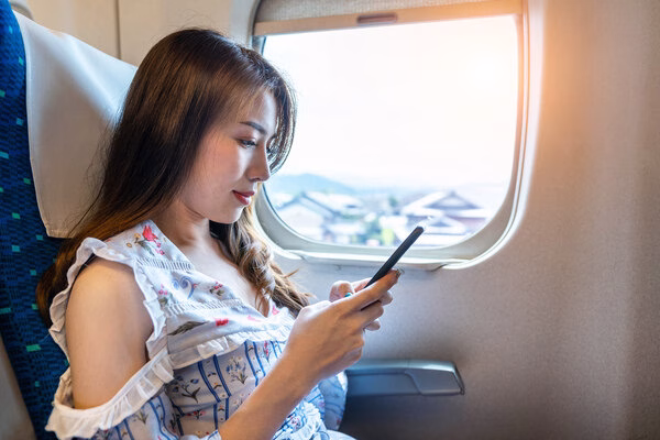 Mujer disfrutando de espacio adicional en el asiento mientras vuela 