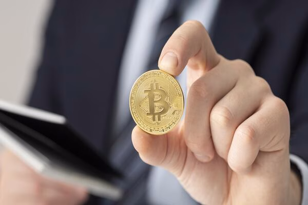Un hombre de negocios sosteniendo Bitcoin, listo para usarlo.
