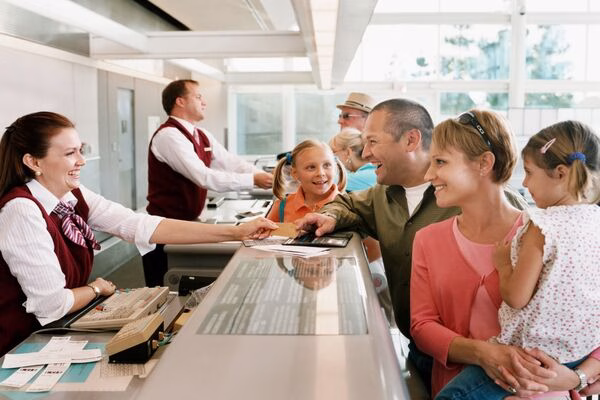 La familia se registra en el mostrador del aeropuerto con los boletos de avión listos.
