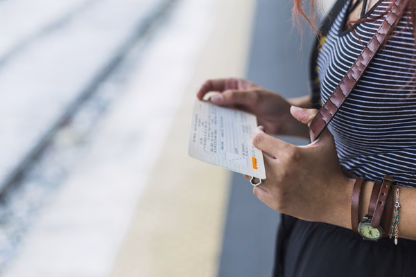 Female tourist checks plane tickets before boarding transportation.