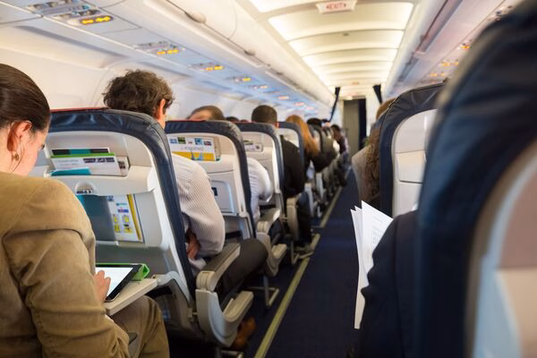 Pasajeros sentados en el avión después de reservar sus boletos de avión.