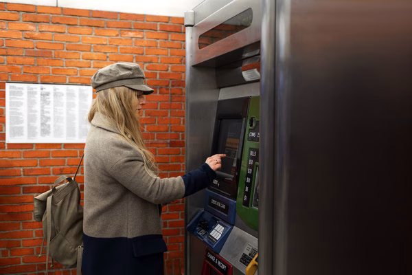 Woman using Bitcoin ATM at outdoor kiosk