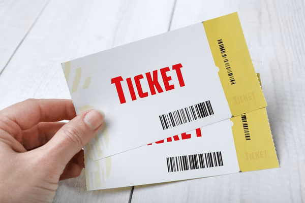 Hand With Two Plane Boarding Tickets