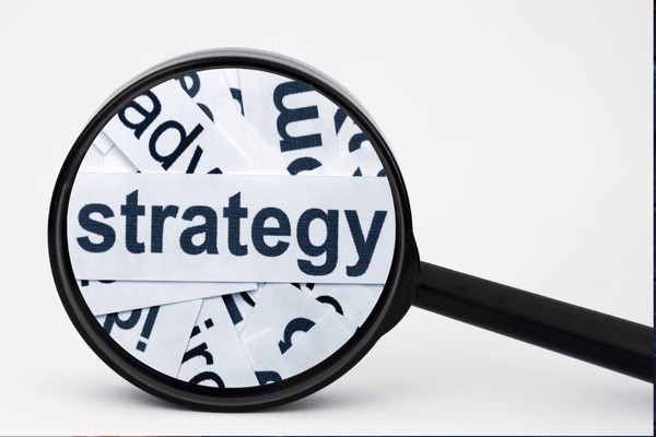 Strategy Word Under Magnifying Glass On Paper