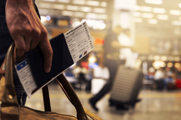 Traveler Holding Passport and Plane Tickets