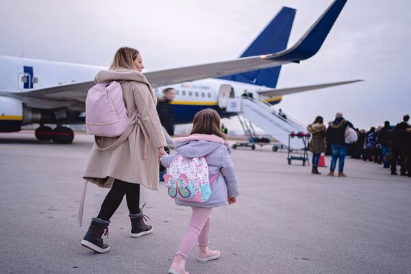 Madre e hija abordan un vuelo después de reservar boletos de avión con anticipación.
