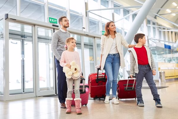 Padres e hijos preparando el viaje después de comprar boletos de avión.