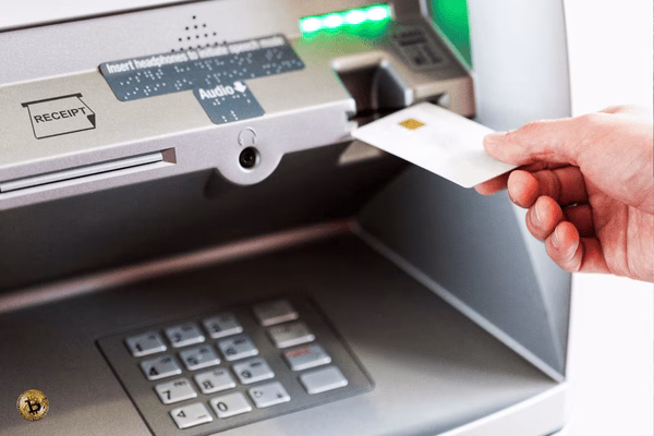 Hand Inserting Card Into Bitcoin ATM Machine