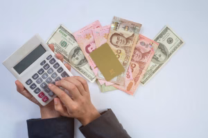 Manos calculando las tarifas de cambio de divisas transfronterizo