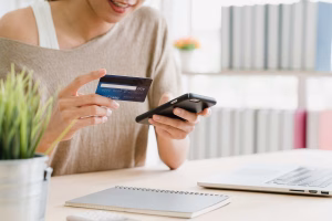 Mujer que realiza un pago transfronterizo con tarjeta de crédito en línea