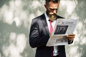 Businessman reading newspaper article about Cross Border Payments trends.
