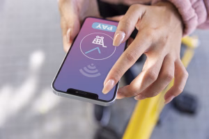Hand using smartphone to process Cross Border Payments digitally