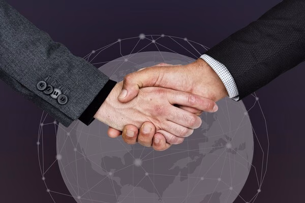 Apretón de manos comercial que simboliza confianza en las transacciones transfronterizas