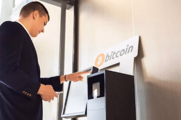 Hombre que usa un cajero automático de Bitcoin para obtener libertad financiera