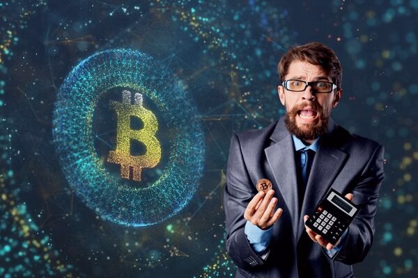 Businessman stressed over Bitcoin ATM fees with digital background.