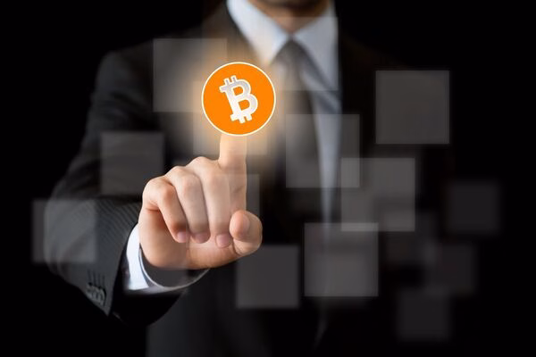 Businessman touching digital Bitcoin ATM icon on virtual screen.