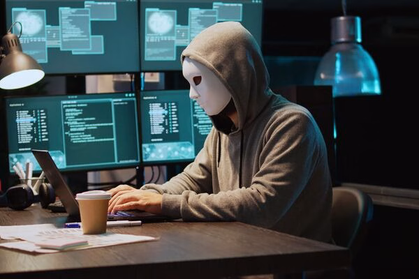 Hacker in mask targeting Bitcoin ATM users through online scams.