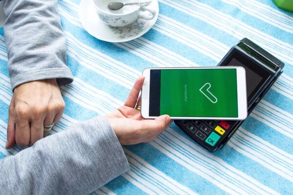 Mobile phone tap used for secure Cross Border Payments transaction.