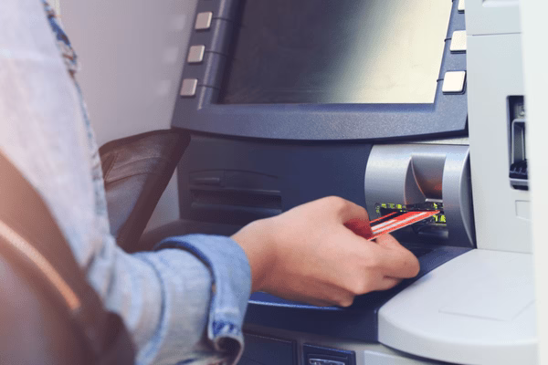 Mano insertando tarjeta en un cajero automático de Bitcoin
