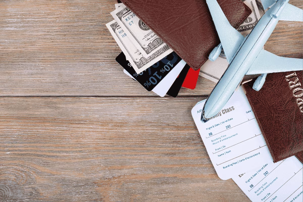 Imprescindibles de viaje con billetes de avión sobre una mesa de madera