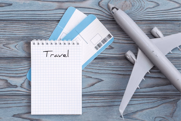 Travel notebook with plane tickets and airplane

