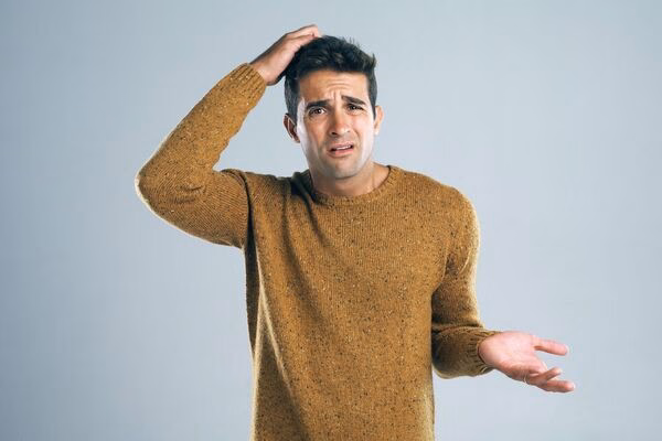 Confused man questioning Cross Border Payments process or fees.

